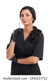 Competent female doctor in black uniform and rubber gloves holding syringe for beauty injection. Positive cosmetologist with dark hair isolated over white background.
