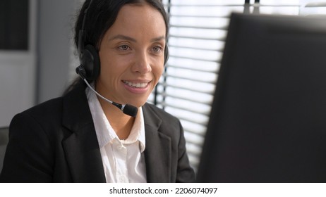 Competent female operator working on computer and talking with clients. Concept relevant to both call centers and customer service offices. - Shutterstock ID 2206074097