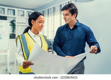 Competent investor investor discuss and brainstorm with engineer on blueprints, construction plans before putting them into action. Professional establishing investment plan for engineering projects. - Shutterstock ID 2233819615