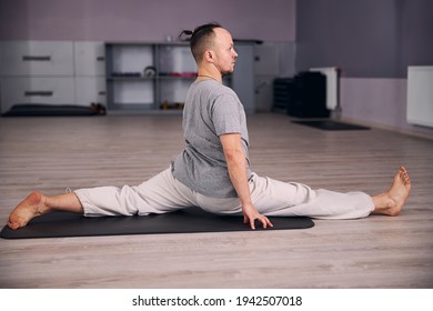 Competent Yoga Instructor Standing In Twine Pose