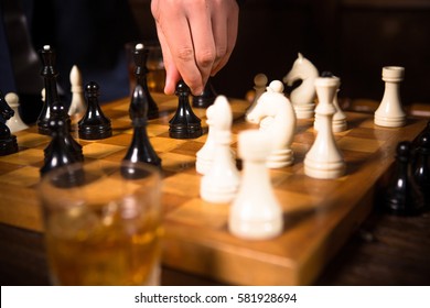 Competition between companies, enterprises, firms. Closeup of chess pieces on chessboard. Rich men playing chess in restaurant. Business concept.