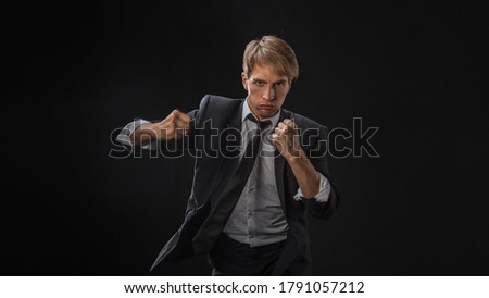 Similar – Image, Stock Photo Close up front portrait of one young middle age athletic woman in sportswear in gym over dark background, standing in boxing stance with hands and fists, looking at camera