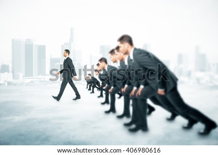 Competition concept with many businessmen about to run and one walking ahead of them on foggy city background