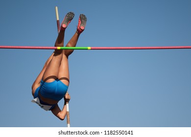 Competition Pole Vault Jumper Female On Blue Sky Background