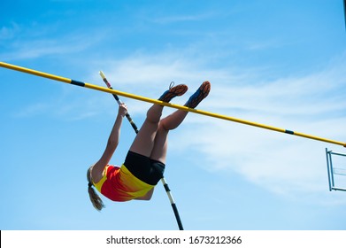 Competition Pole Vault Jumper Female On Blue Sky Background