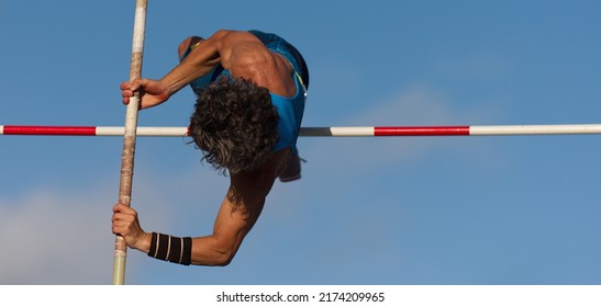 Competition Pole Vault Jumper Male On Blue Sky Background