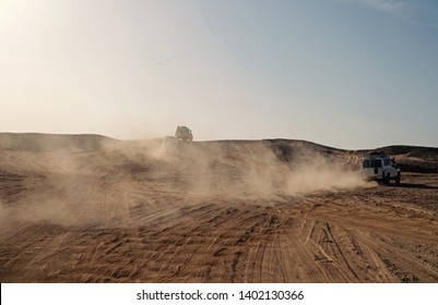 Competition Racing Challenge Desert. Car Overcome Sand Dunes Obstacles. Car Drives Offroad With Clouds Of Dust. Offroad Vehicle Racing Obstacles In Wilderness. Endless Wilderness. Race In Sand Desert.