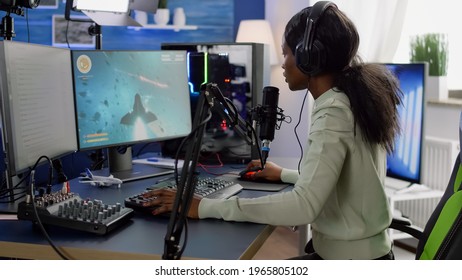 Competitive Black Gamer With Headphones Using Stream Chat On Powerful Computer Winning Online Shooter Game Late At Night. Virtual Online Streaming Cyber Checking Sound Performing In Gaming Tournament