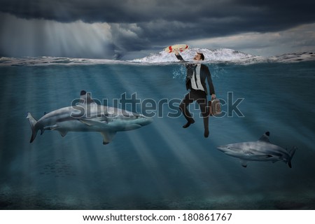 Competitive business concept with businessman swimming among sharks in stormy seas