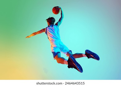 Competitive man, athlete in motion, training, playing basketball against gradient background in neon light. Concept of sport, competition, active and healthy lifestyle, game - Powered by Shutterstock