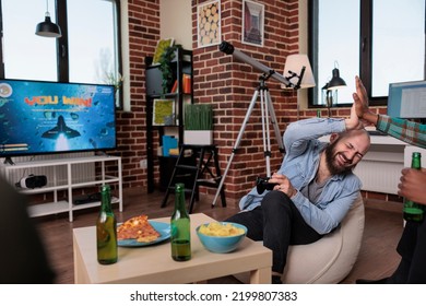 Competitive Man Playing Video Games On Tv And Winning, Celebrating Victory And Feeling Happy With People Drinking Beer. Enjoying Shooter Game Competition Win At Fun House Party.