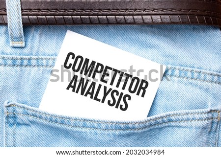 COMPETITOR ANALYSIS words on a white paper stuck out from jeans pocket. Business concept.