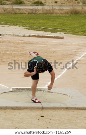 A competitor in the men's shot put event during a college track meet.