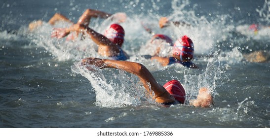Wettbewerber, die zu Beginn des Triathlon ins offene Wasser schwimmen