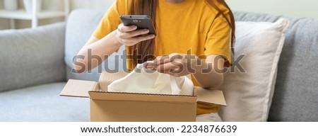 Complaint asian young woman hand using mobile phone take a photo product order from retail store after open carton box, received online shopping parcel wrong with support shop want to return package.