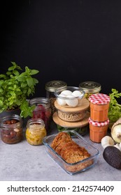 Complete batch cooking scene with several piles of glass containers full of homemade food with a dark copy space background. - Shutterstock ID 2142574409