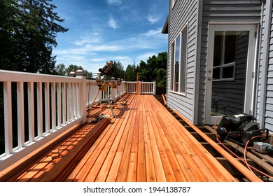 Complete home outdoor deck remodel with new red cedar wood planks being installed