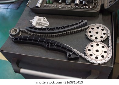 A complete new kit for replacing the timing chain of an automobile engine is laid out on a gray tool cart in an auto repair shop - Shutterstock ID 2163915413