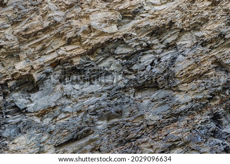 Complete setting of the textures of the face of a smooth rock with stratum outdoors.