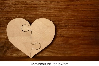 complete wooden heart shape jigsaw puzzle on wood board  background . 2 two pieces. two person in relationship. 