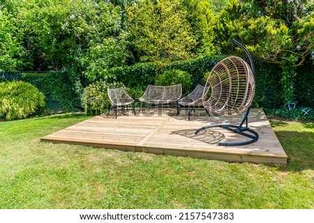 A completed decking construction in a garden in Market Harborough, UK in early summer