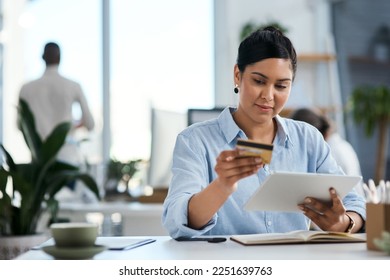 Completing business payments with ease. Shot of a young businesswoman using a digital tablet and credit card in an office. - Shutterstock ID 2251639763