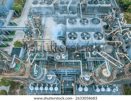 Complex chemical processing facility showing intricate network of pipes and industrial equipment.