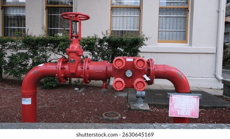 Complex fire hydrant pipes, valves and switches, on side of commercial building. Sydney, 10 May 2025.
