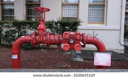 Complex fire hydrant pipes, valves and switches, on side of commercial building. Sydney, 10 May 2025.