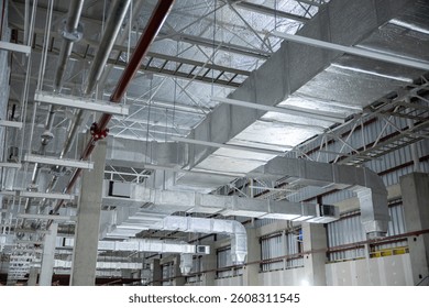 A complex HVAC duct system installed in an industrial building ceiling, showcasing advanced air distribution and ventilation infrastructure.