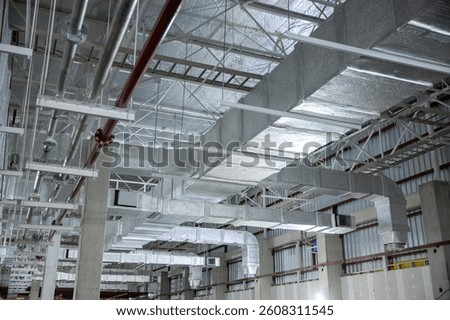 A complex HVAC duct system installed in an industrial building ceiling, showcasing advanced air distribution and ventilation infrastructure.
