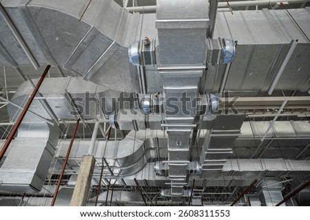 A complex HVAC duct system installed in an industrial building ceiling, showcasing advanced air distribution and ventilation infrastructure.
