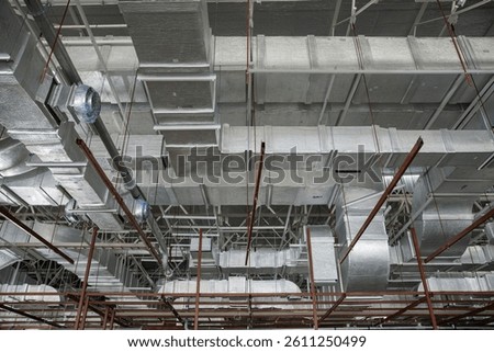 A complex HVAC duct system installed in an industrial building ceiling, showcasing advanced air distribution and ventilation infrastructure.