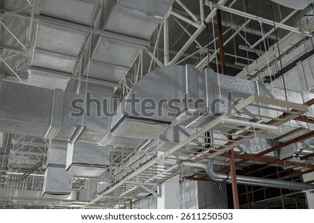 A complex HVAC duct system installed in an industrial building ceiling, showcasing advanced air distribution and ventilation infrastructure.