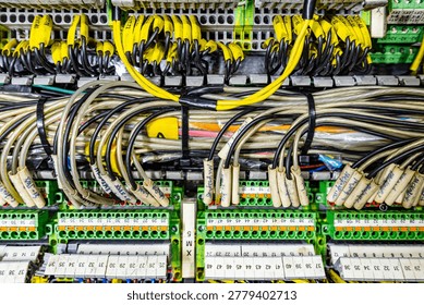 Complex industrial electrical control panel with many labeled yellow wires and terminal blocks in a distribution board