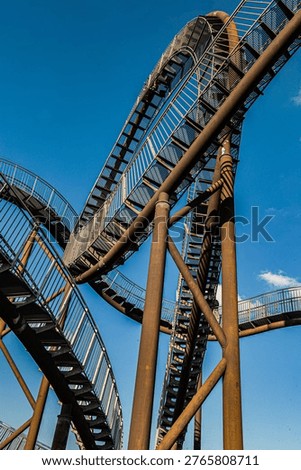 Complex intersection of staircases and loops in the Tiger and Turtle sculpture, showcasing its roller coaster inspired design.