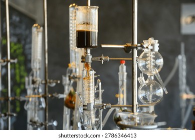 Complex lab distillation and extraction equipment with glass beakers and flasks holding dark liquid, ideal for science, chemistry, and research concepts.