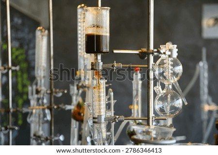 Complex lab distillation and extraction equipment with glass beakers and flasks holding dark liquid, ideal for science, chemistry, and research concepts.