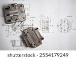 Complex metal component showcasing precision manufacturing, placed on an engineering blueprint.