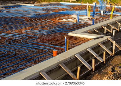Complex network of underfloor heating pipes installed over a reinforced base, prepared for concrete pouring in an energy-efficient home foundation