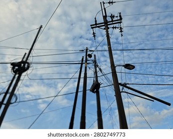 Complex Network of Utility Poles and Power Lines Against a Dramatic Sky
​This high-definition, landscape-oriented photograph captures a dense, intricate cluster of utility poles and crisscrossing power lines set against a backdrop of textured, cloud-dappled blue sky. The powerful silhouette effect emphasizes the structural complexity of modern electrical infrastructure, creating a compelling visual narrative of urban connectivity. This professional-grade asset is an ideal choice for editorial layouts focusing on energy distribution, architectural mood boards, urban landscape storytelling, or as an evocative, industrial-inspired background for creative design projects requiring a strong, atmospheric impact.