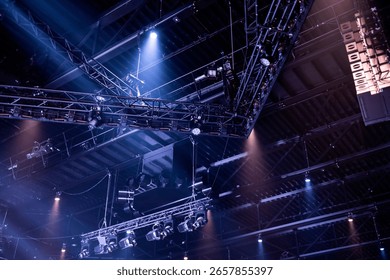 Complex overhead lighting infrastructure with extensive truss system creating dramatic atmospheric lighting beams