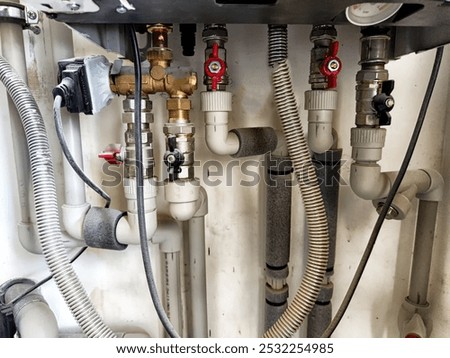 A complex plumbing setup featuring various pipes and valves, indicating ongoing service and installation work in a home environment.