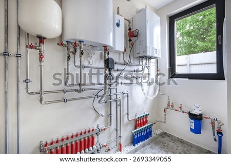 A complex plumbing system is visible in this residential utility room. Tanks and pipes are neatly arranged, showcasing modern heating and water solutions for the home.