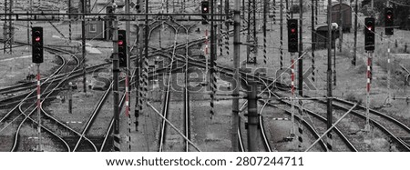 A complex railway network with multiple tracks and red signal lights, showcasing intricate infrastructure and transportation elements.