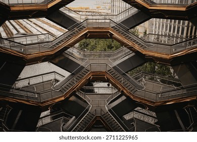 A complex, symmetrical architectural design of interconnected staircases and platforms, bathed in warm, inviting light.