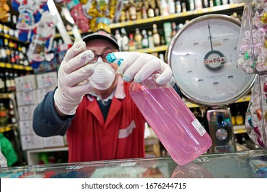 For Compliance With Health Regulations Against Covid-19 A Grocery Store Clerk Disinfects His Gloves. Milan, Italy - March 2020