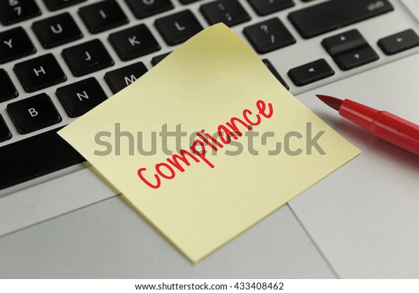 Compliance sticky note\
pasted on the\
keyboard