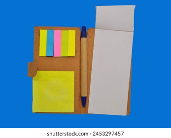 A complimentary gift consisting of a notepad, post-it notes, and a pen, presented in an isolated setting against a blue background.