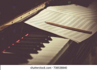 Compose Concept. Pencil And Sheet Music On The Piano Keyboard